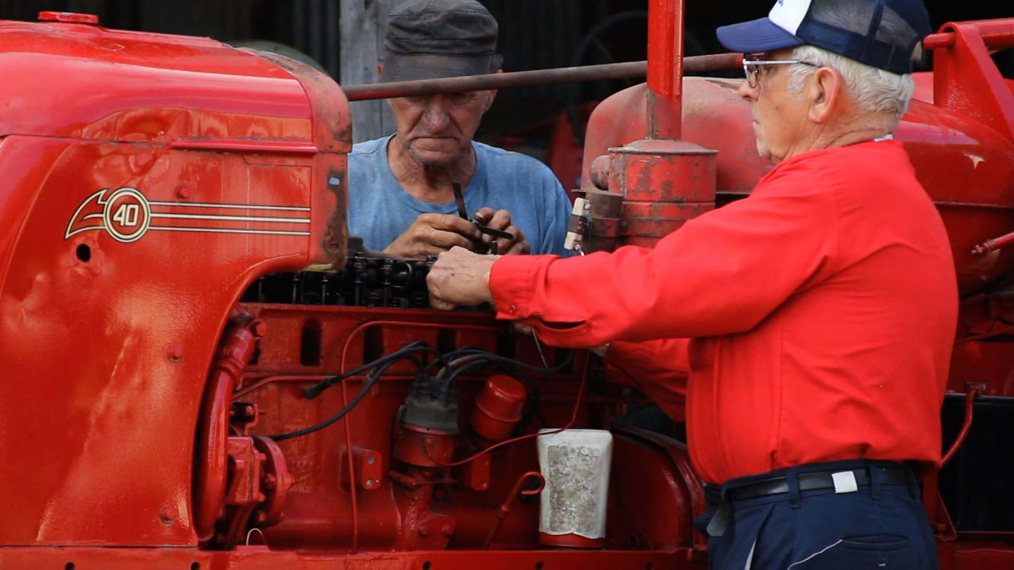 Farmers working on a tractor