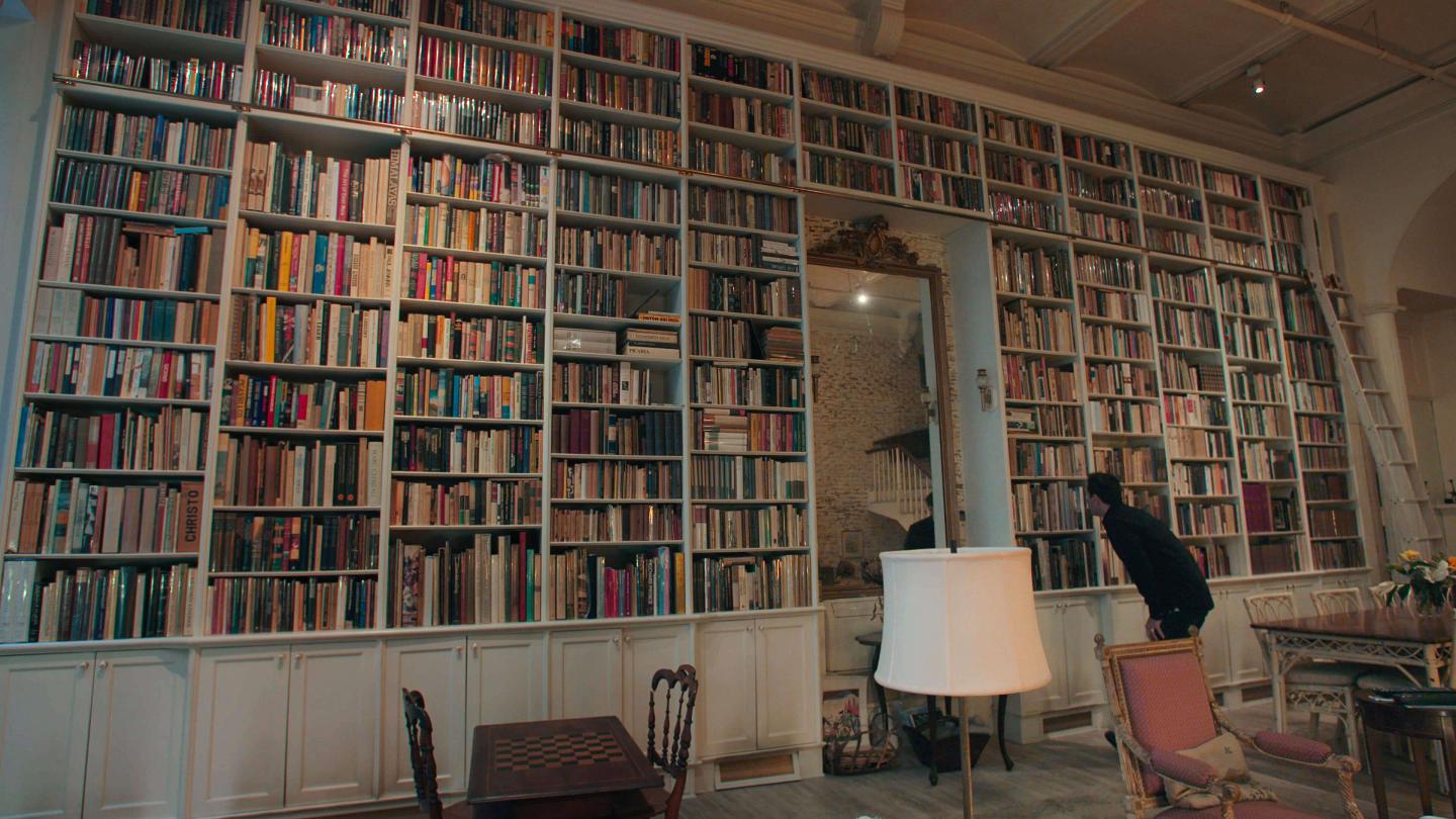 Adam Weinberger examining a bookshelf