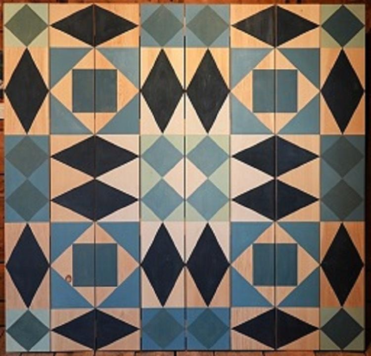 geometric shapes in shades of blue painted on plywood.