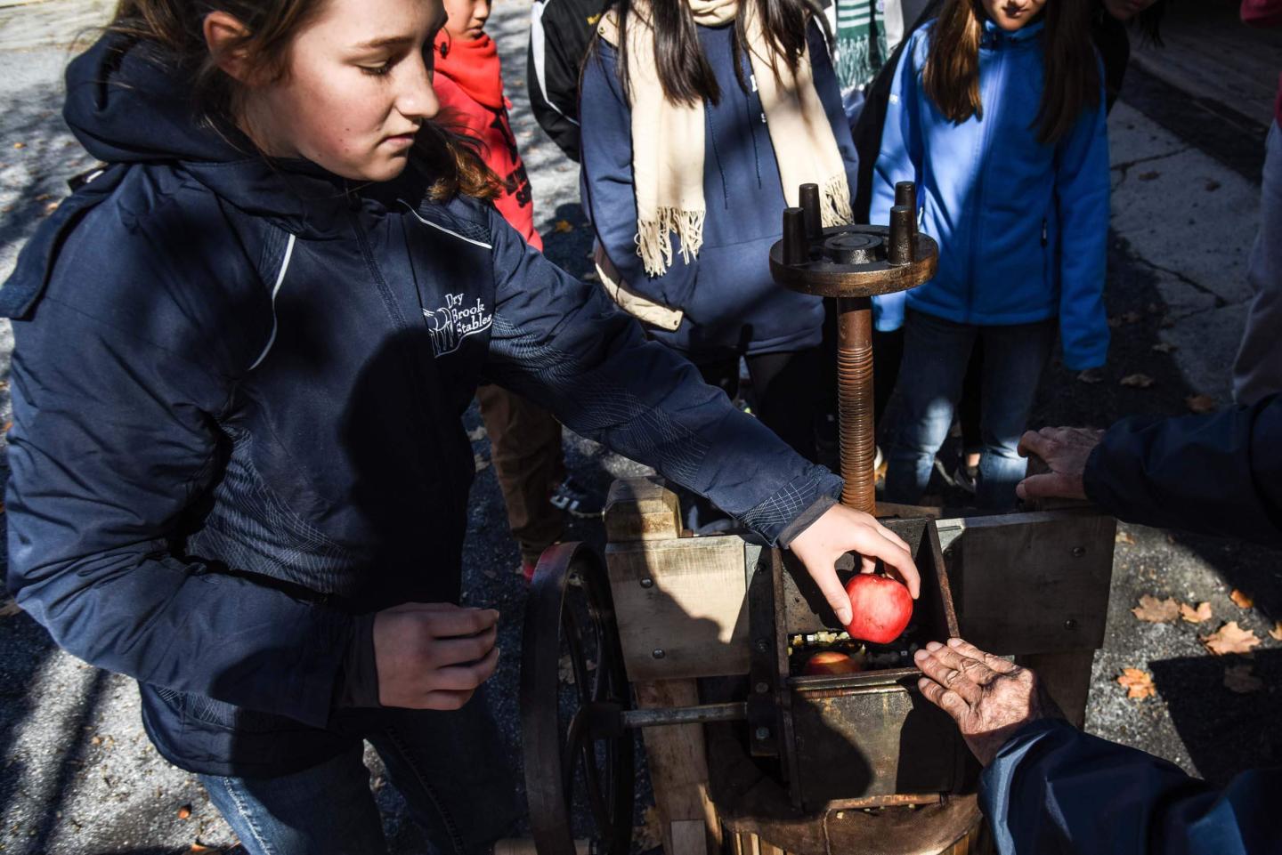 Children making apple cider.