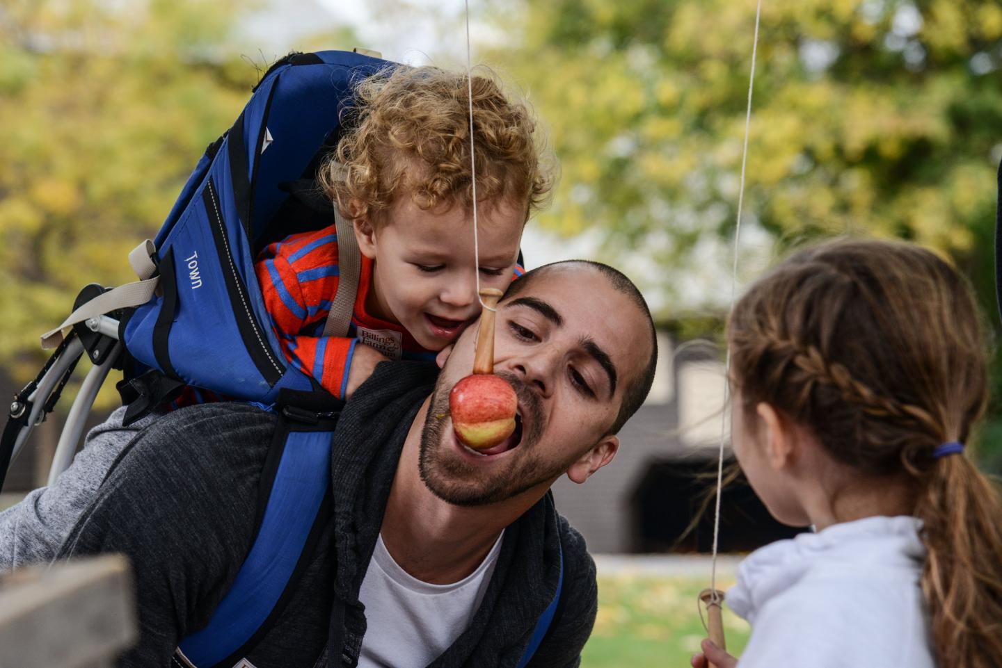 Guests eating apples-on-a-string.