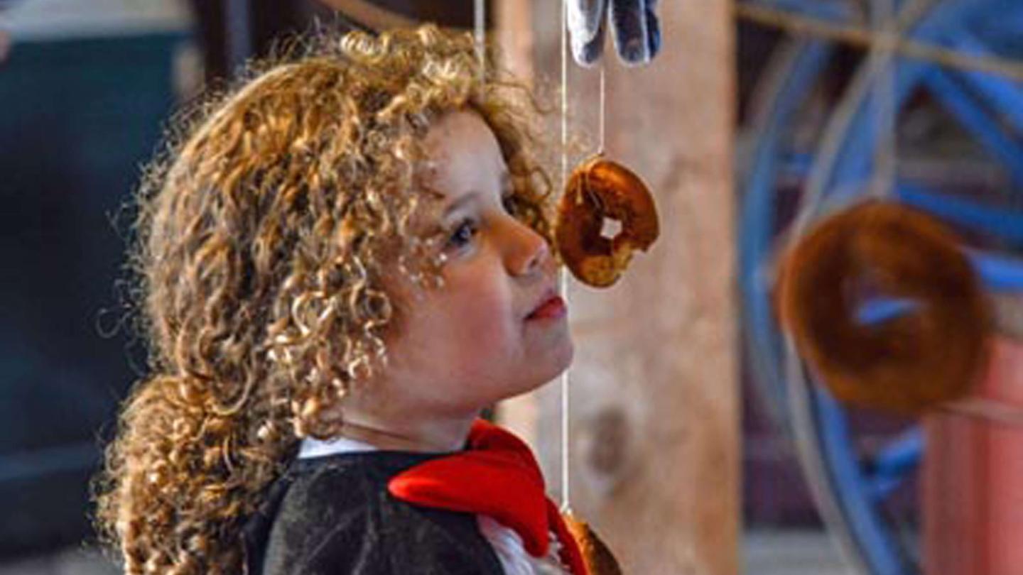 Child eating a doughnut.