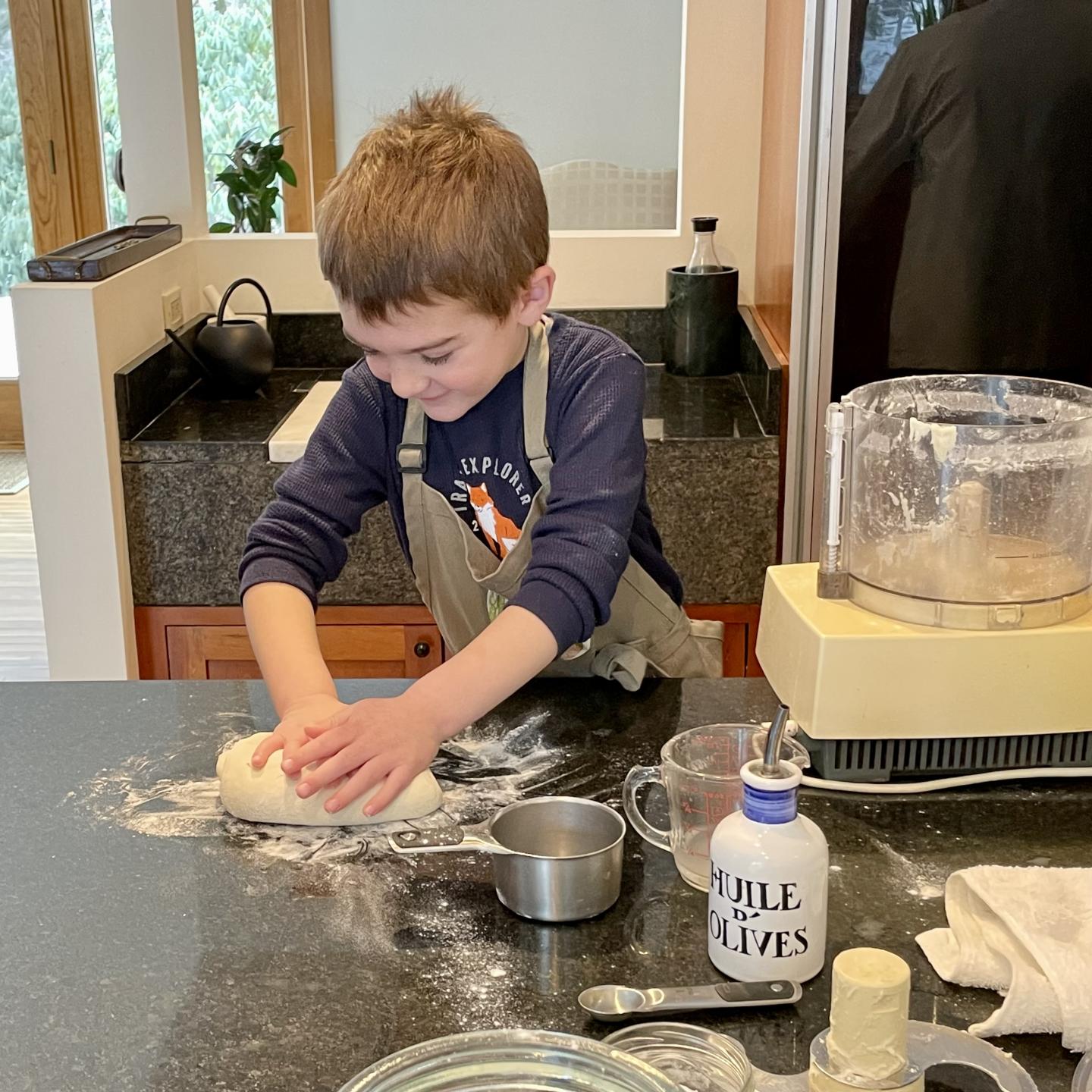 Little boy making pizza dough