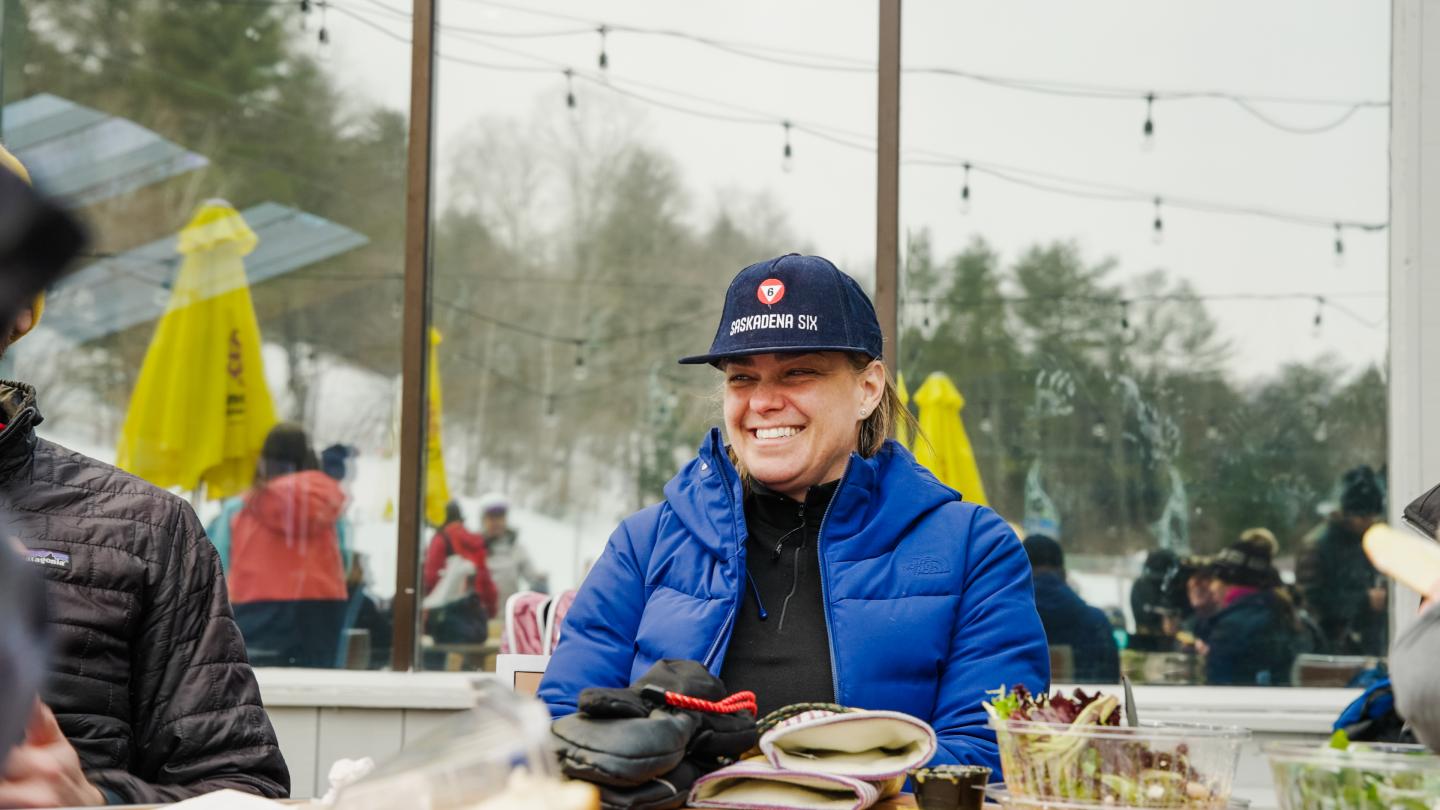 Smiling skier with a Saskadena Six flatbrim hat