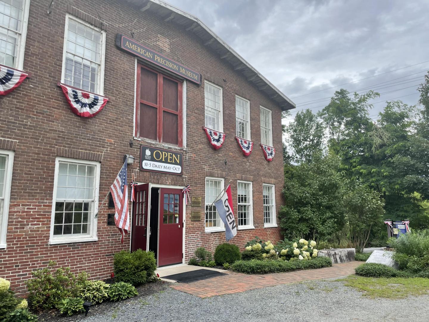 A red brick building with patriotic banners under a stormy sky
