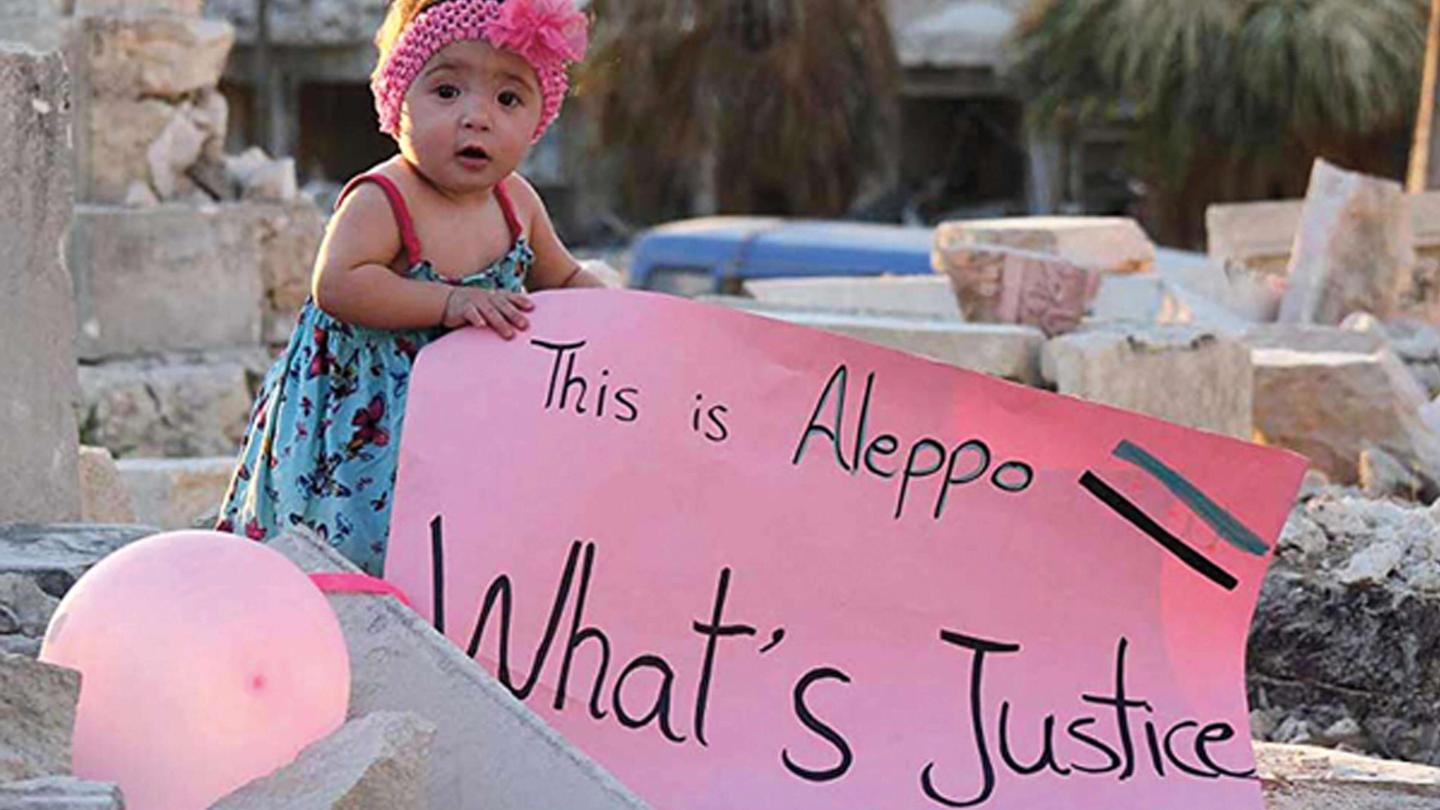 Baby holding "This is Aleppo whats justice?" sign