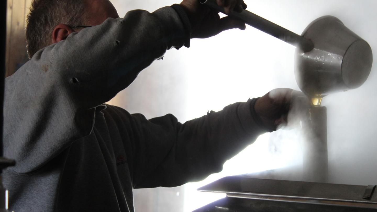 man making maple syrup boiling