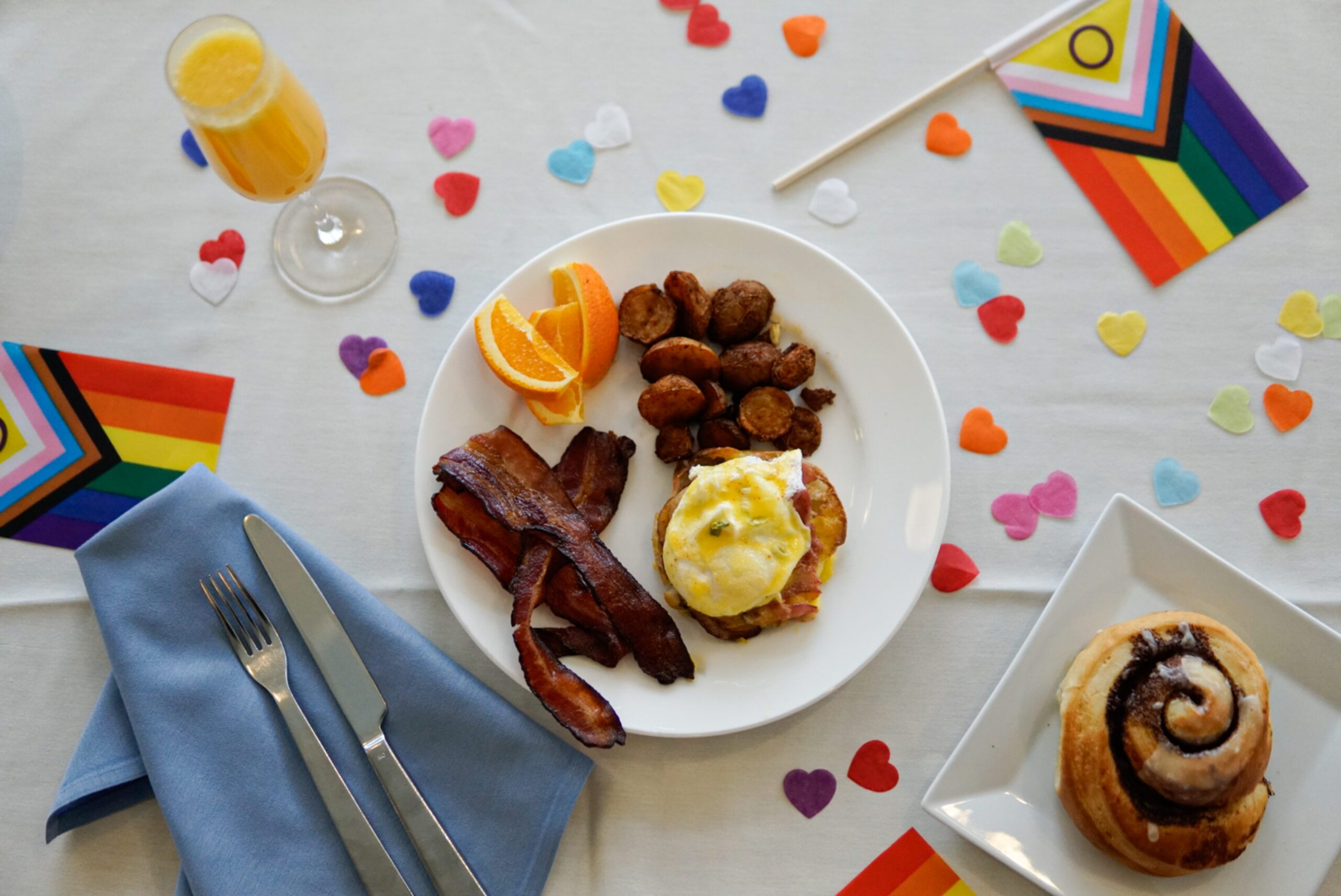 A plate of brunch food with rainbow confetti and pride flags
