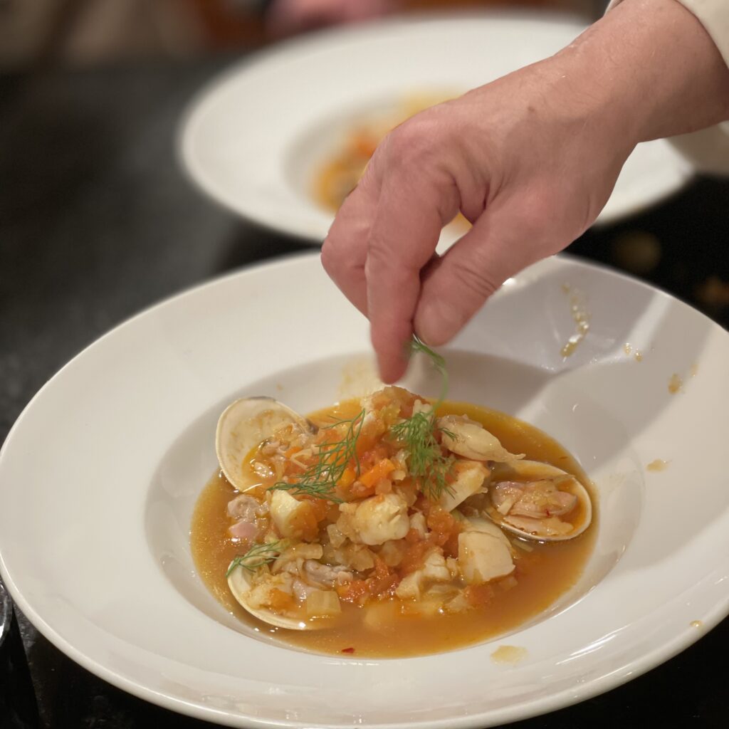 Garnishing a bowl of fish stew