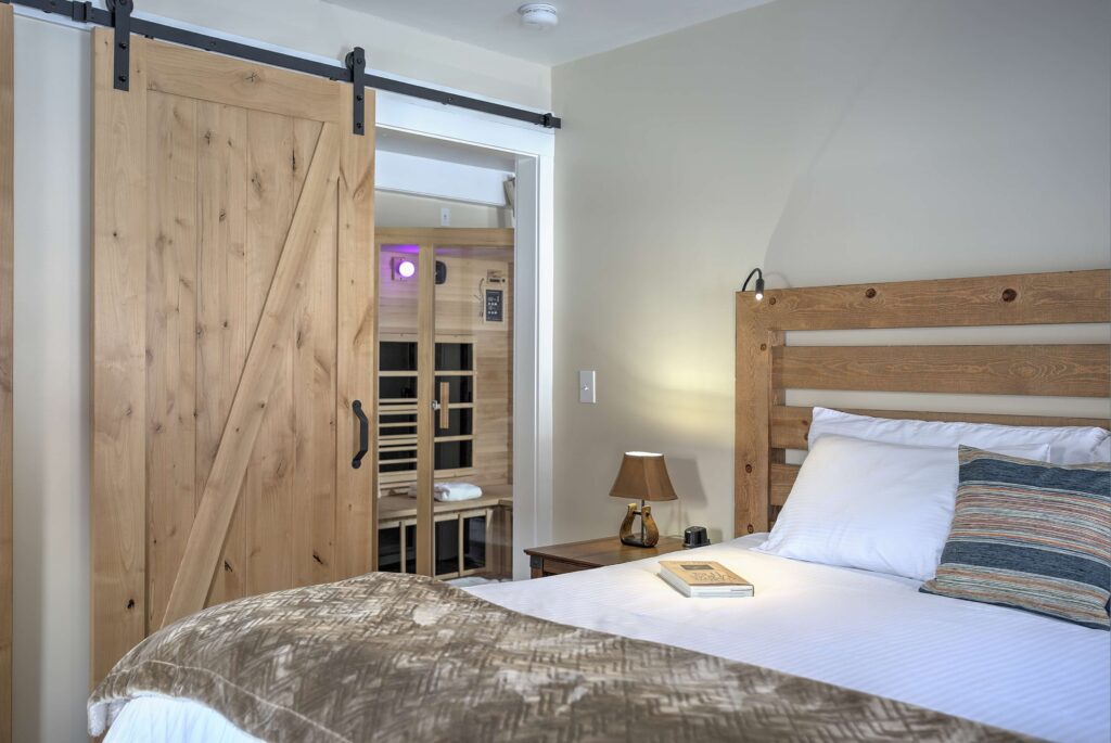 Bedroom with wooden sliding door and sauna in background