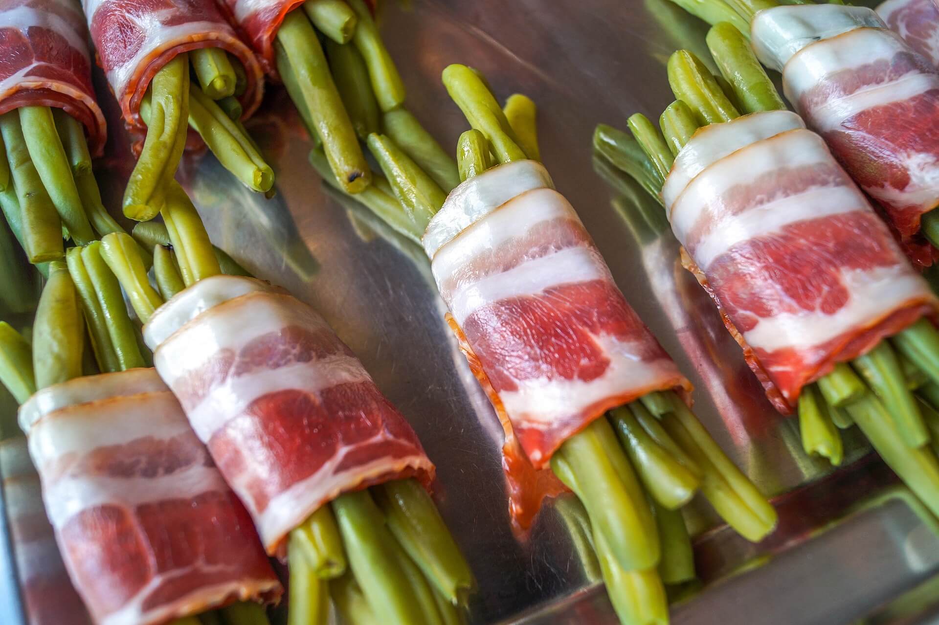 Beans wrapped in bacon cooking