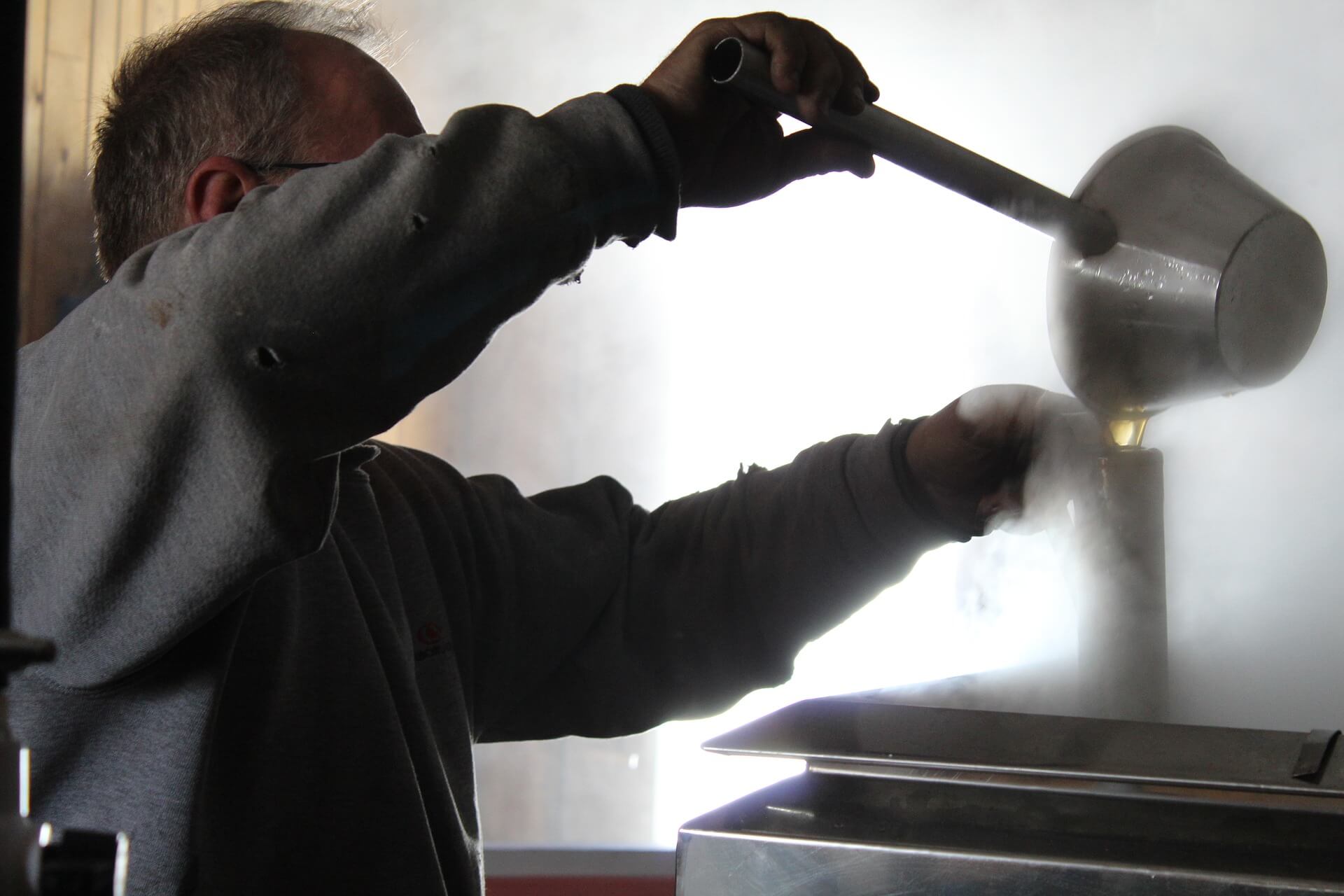man making maple syrup boiling